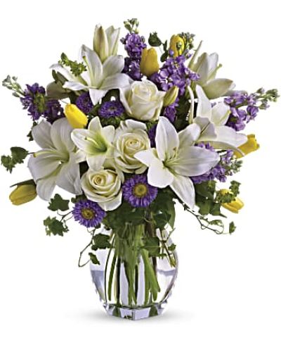 Dance into spring! Send this feminine bouquet of favorite spring flowers to brighten someone's home with the playful beauty of nature. Such a pretty way to say, "I'm thinking of you!"

This white, lavender and yellow bouquet includes white asiatic lilies, cream roses, yellow tulips, lavender stock, lavender matsumoto asters and greens including bupleurum, ivy and seeded eucalyptus. Delivered in a gorgeous reception vase.