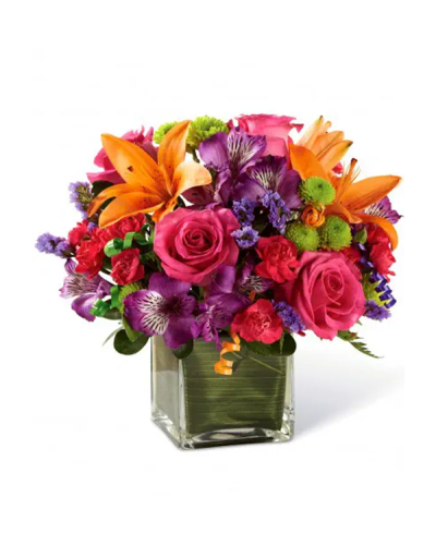 Birthday blooms that are ready to get your recipient's special day started, this flower bouquet is bright, happy, and ready to celebrate! Hot pink roses and orange Asiatic Lilies are vibrant and fun surrounded by purple Peruvian Lilies, hot pink mini carnations, green button poms, purple statice, and an assortment of lush greens. Accented with assorted curling ribbons to give it that party feels and presented in a clear glass cubed vase lined with ti leaf green material for added beauty, this unforgettable birthday bouquet is that ultimate surprise that will make them feel the love on their big day.